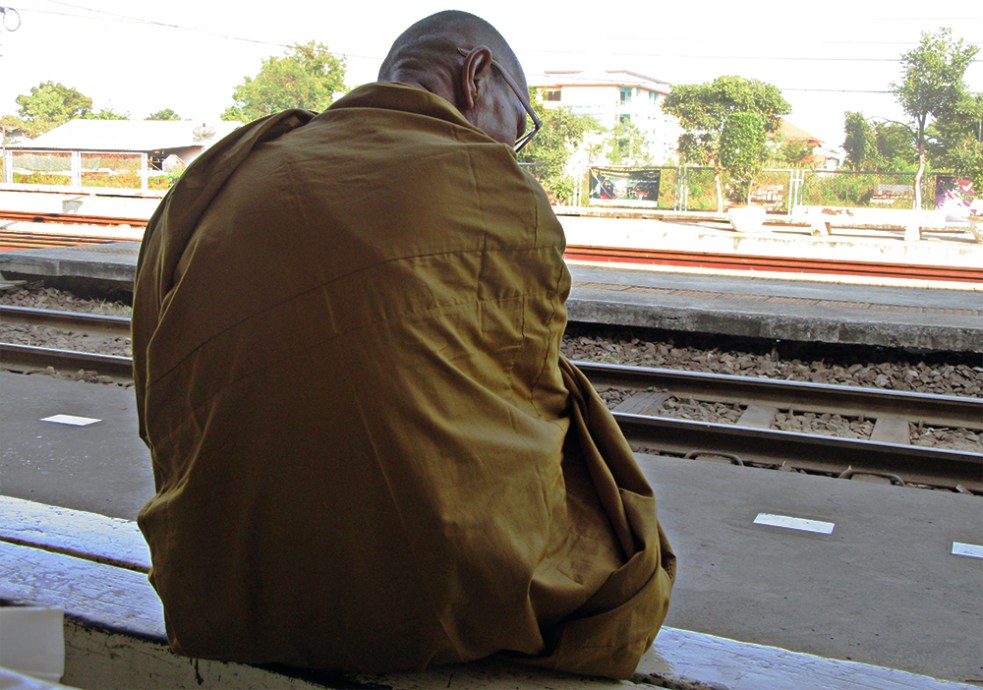 Monje esperando en la estación de tren de Ayutthaya